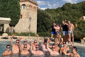 A group of people in a pool holding drinks.