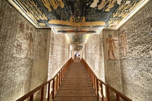 A hallway with egyptian paintings on the ceiling.