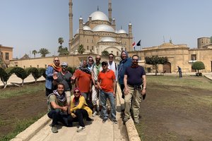 A group of people posing for a photo in front of a large building.