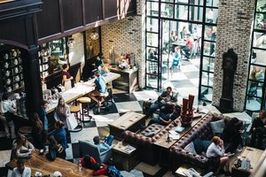 An aerial view of a lobby with people sitting at tables.