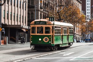 A green trolley on a street.