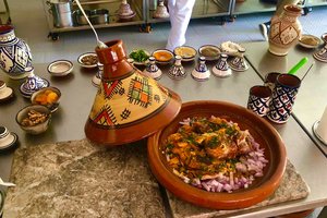 A bowl of food on a table next to other dishes.