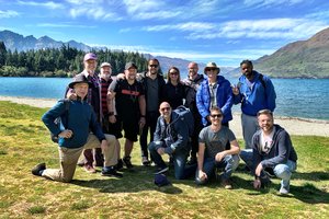 A group of people posing for a photo in front of a lake.