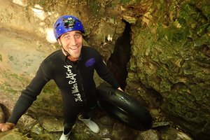 A man in a wetsuit standing in a cave.