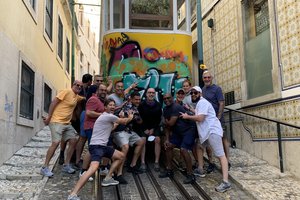 A group of people posing in front of a cable car.