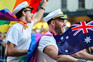 Two men are waving australian flags in a parade.