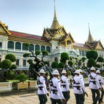 Uniformed guards marching in formation at the grand palace in bangkok, thailand.