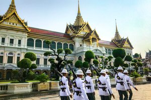 Uniformed guards marching in formation at the grand palace in bangkok, thailand.