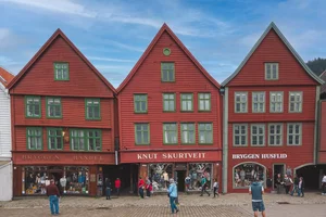 A group of people walking in front of a red building.