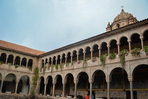 A courtyard with columns and arches in front of a building.