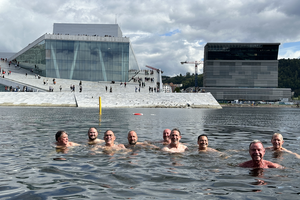 a group of men swim in front of modern building