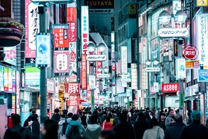 Vibrant and crowded shopping street in japan at night with neon signage.